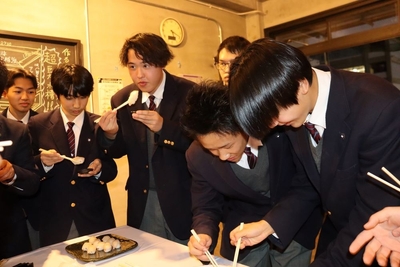 自分たちで育てたタマカイを試食する生徒たち