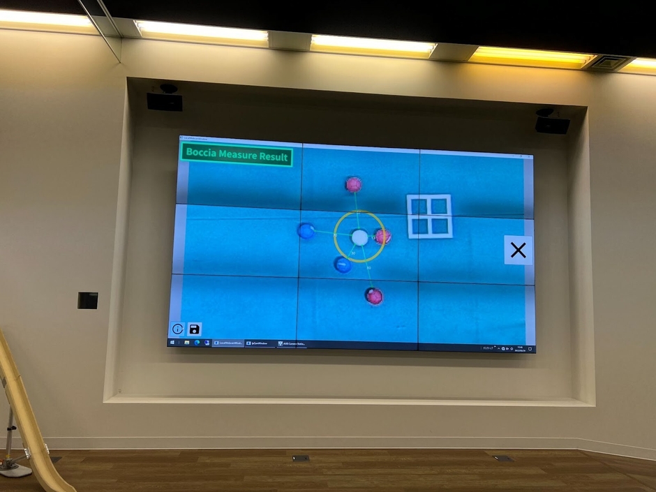 株式会社CAC Holdingsの本社1階にある、CACボッチャコート　壁面には天井カメラと連携し、ゲームの盤面を映し出す大型モニターも備える