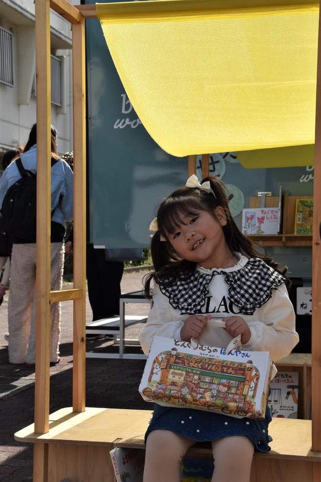 自動車図書館の「Book Worm号」の屋外ファニチャーで笑顔を見せる参加者