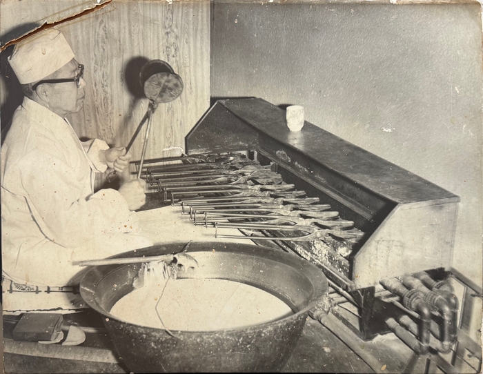 創業者(松久勇)が手焼き煎餅を焼く様子