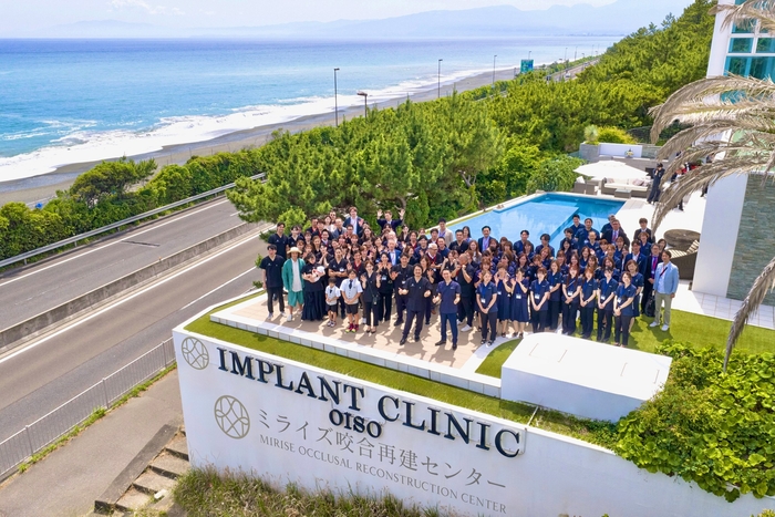 相模湾を望む大磯拠点。約150名の関係者・スタッフが参加した提携記念式典の集合写真。