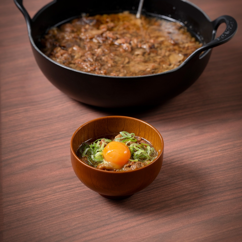 大阪の味 牛スジ煮込みは、トッピングに味付け卵黄やネギ、七味をご用意。