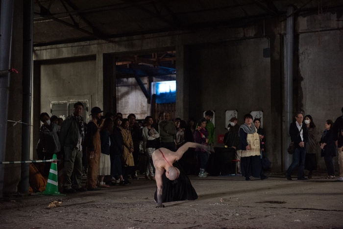 巨大なサルベージ倉庫で行われた公演。観客を引き連れながらパフォーマンス。