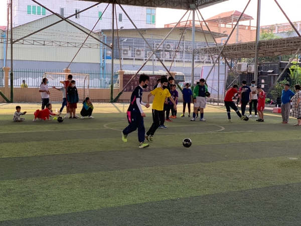 子どもたちは学生と一緒にボールを追いました