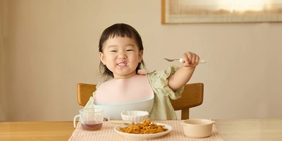 キャッチ力と着け心地で子どもが食事に集中！ 良いとこどりの異素材コラボお食事エプロンが誕生。 【ごはんを楽しむエプロン】を8月下旬に発売