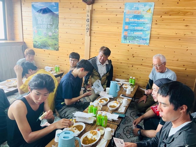 八合目の山小屋で食事を取る学生たち