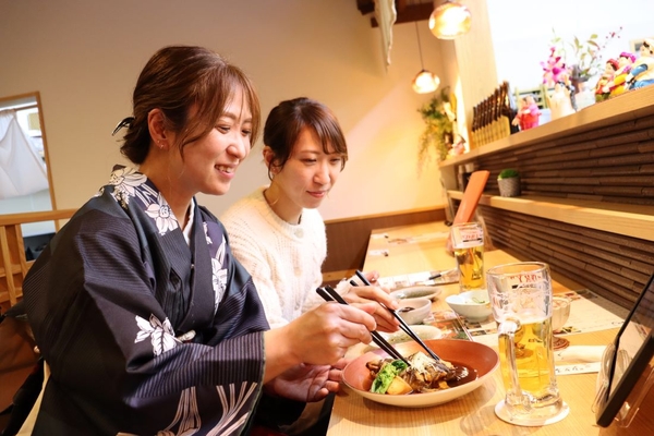 メバルの煮付けに舌鼓を打つ女性客