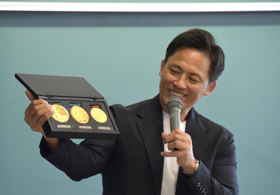 ３個の金メダルを披露する野村特任教授