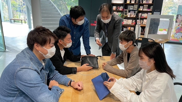"サメ革バディバッグPeg"の完成品を確認する学生ら