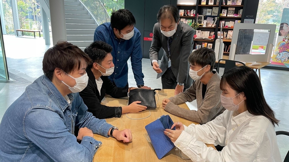 "サメ革バディバッグPeg"の完成品を確認する学生ら