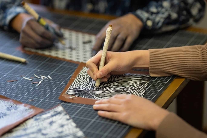 小沼氏から教わりながら型紙を掘る様子