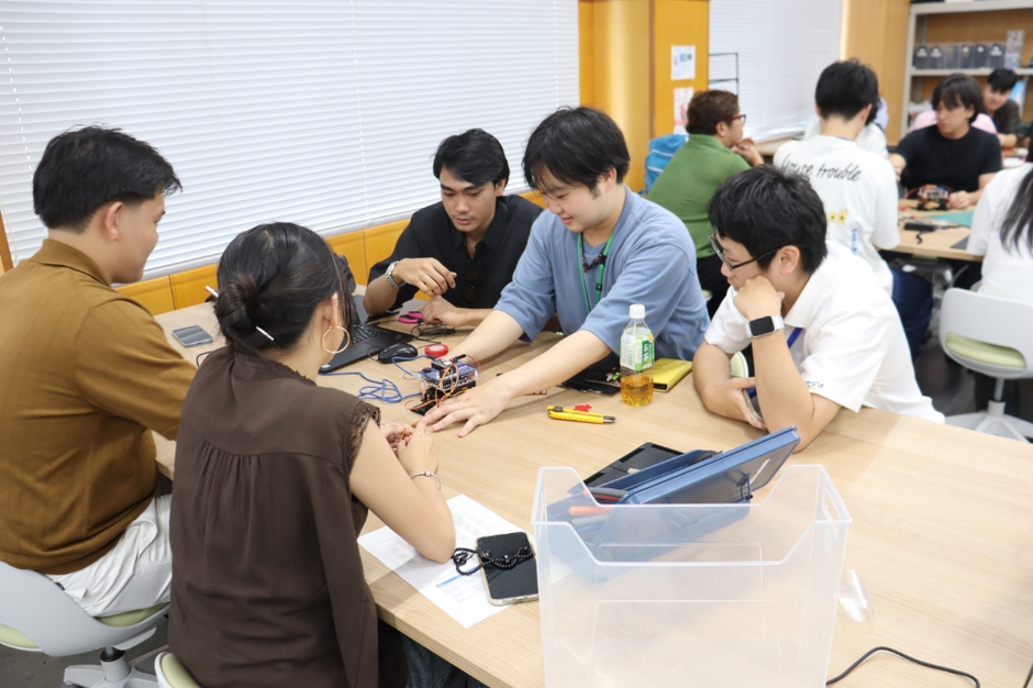 ロボットを触りながら説明している大学院生の牛上瑠星さん