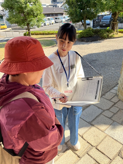 アンケート調査で訪れた方から聞き取りをする若杉さん