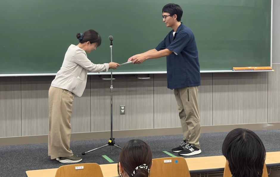 伊藤センター長から助成決定通知書を受け取る学生