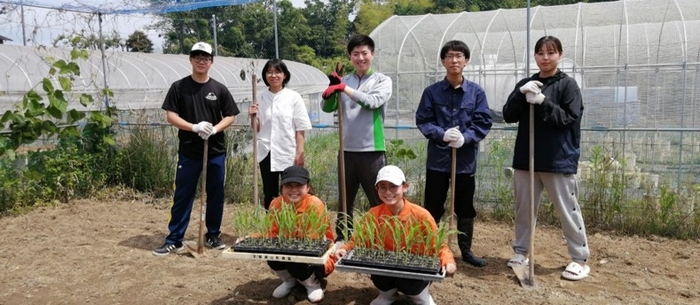 近畿大学農学部の実験圃場での実習の様子。近畿大学農学部の学生(後列)と桂高等学校の生徒(前列)