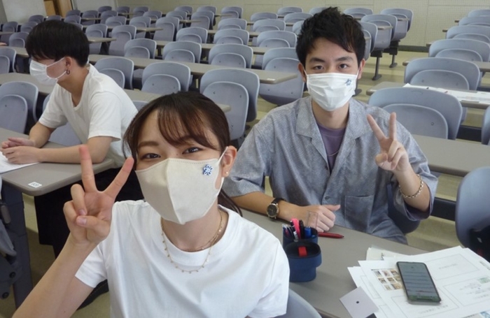 共同開発のマスクチャームをつけた学生