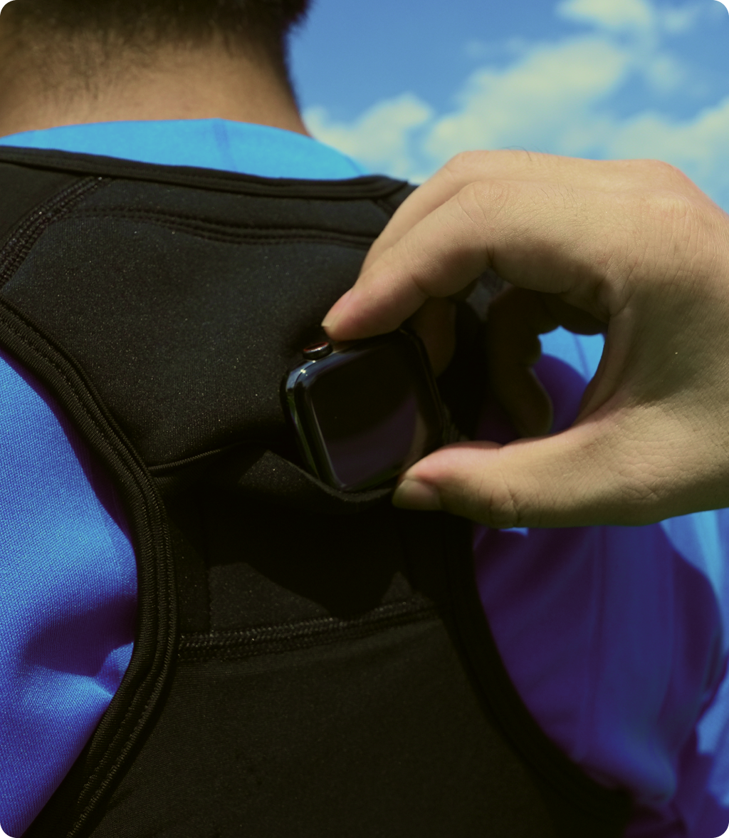 専用スポーツベストの背中にアップルウォッチを入れるシーン