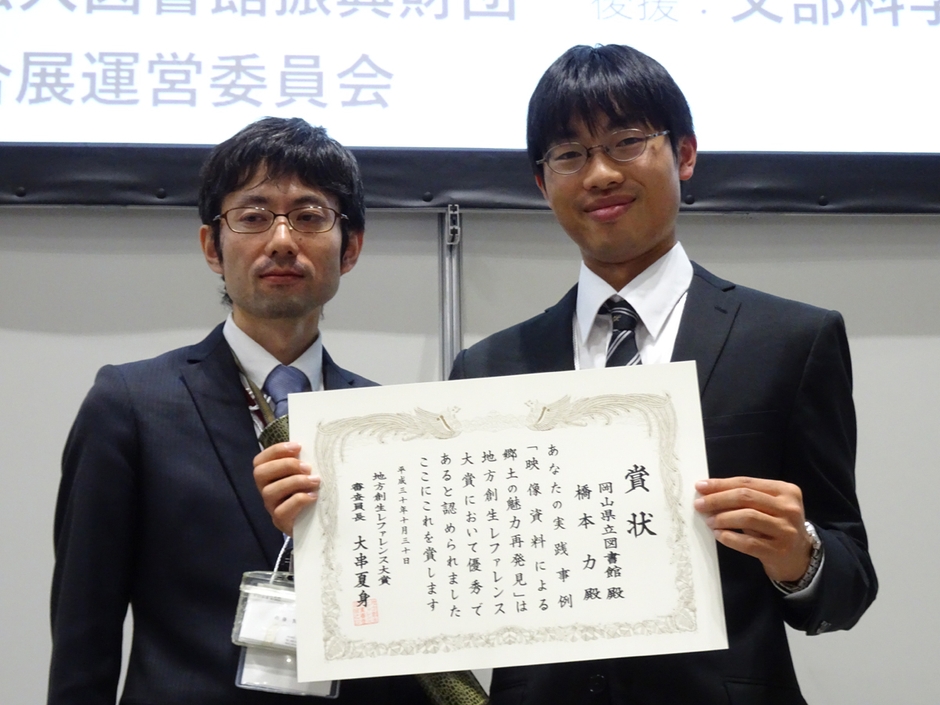 授賞式に出席した橋本さん(右)と岡山県立図書館サービス第2課社会科学班の佐藤賢二さん