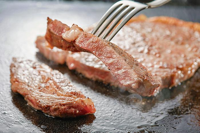 ライブキッチンから焼きたてをご提供するステーキ　※ステーキは調味牛脂を注入した加工肉です。