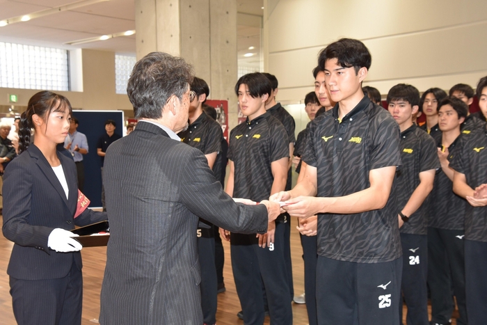 援助金を渡す校友会の矢野専務理事