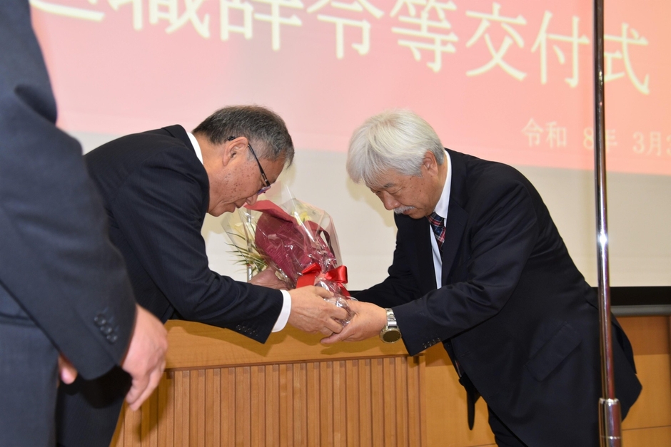 野口学長から花束を受け取る理工学部の服部友一教授