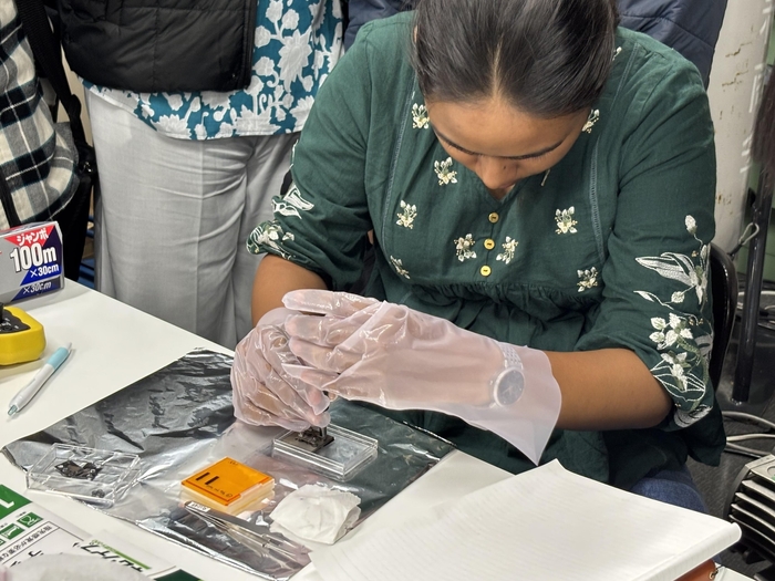 指示を受けながら試料の取り付けを練習するインドの学生