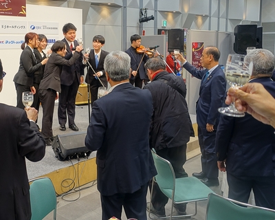 ステージから「乾杯」の声を上げる学生たち