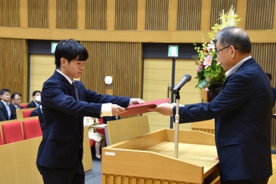 野口学長から学業優秀奨学生の決定通知を受け取る井口さん