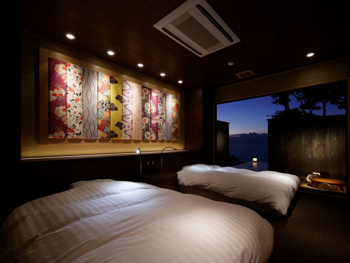 季音庵 風乃音ベッドルーム。ベッドバックには煌びやかな丹後ちりめんのしつらえ