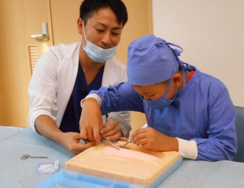 医学部堺病院で実施した職業体験で、縫合を行う小学生の様子(平成28年10月)