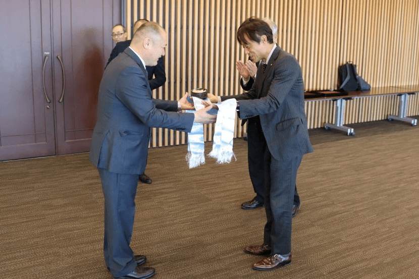 調印式後の行事で、モンゴル式の儀礼でバダムハタン所長（左）を迎える加計学園の加計役理事長（右）