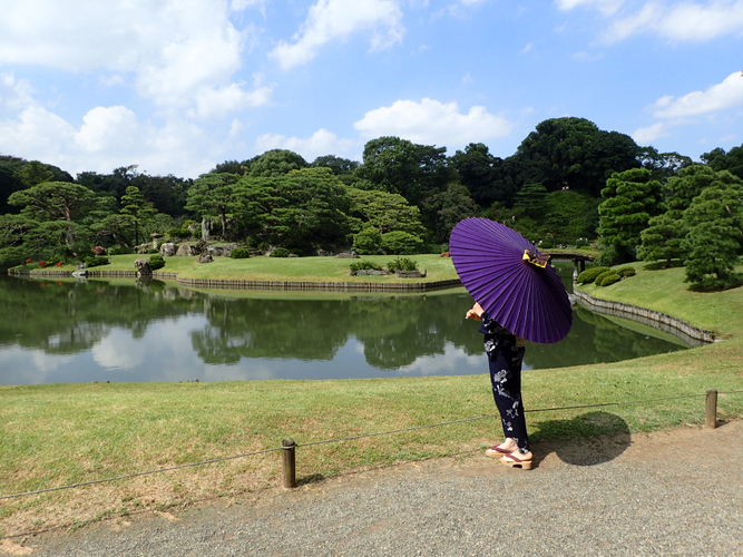 夏の庭園を和傘で散策する来園者（昨年の六義園のようす）