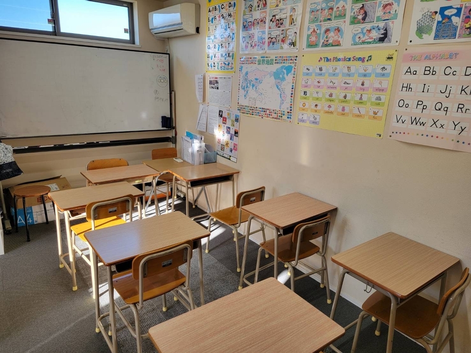 フリースクール滝野川高等学院浦和美園校の教室内観。机と椅子が配置され、英語学習教材が壁に掲示されている