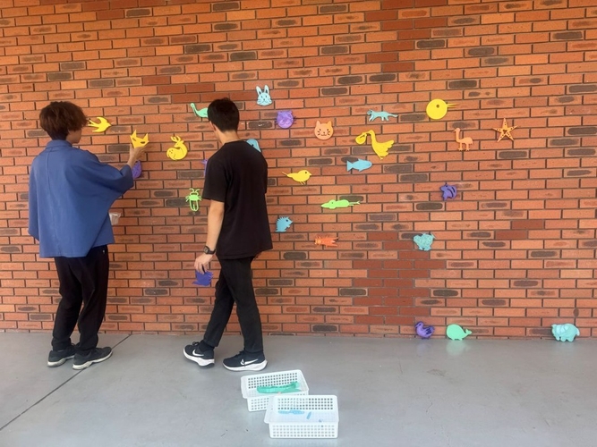 「壁面プラ継ぎ」を取り付ける学生たち（芸術学部・原田明夫研究室提供）