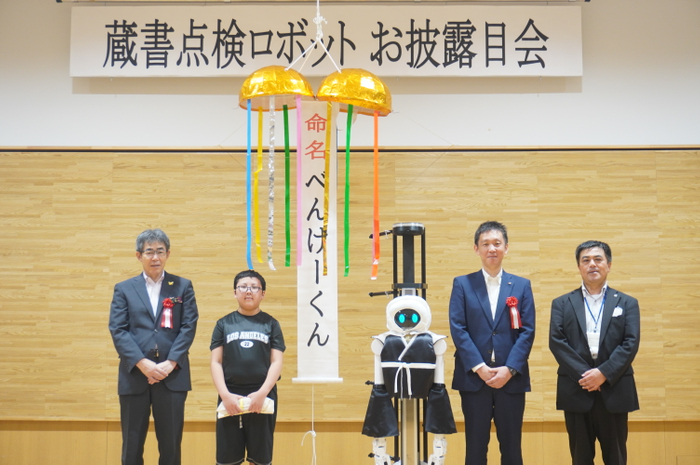 平泉町学習交流施設 エピカで開催した、KoKoBoシステム搭載 DX業務ロボット1号機「べんけーくん」のお披露目式の様子。 （写真左は平泉町副町長 菅原 幹成様、左から二番目は、愛称投票者代表の高橋 理央さん）