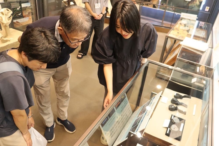市川学芸員（右）の説明に聞き入る来館者