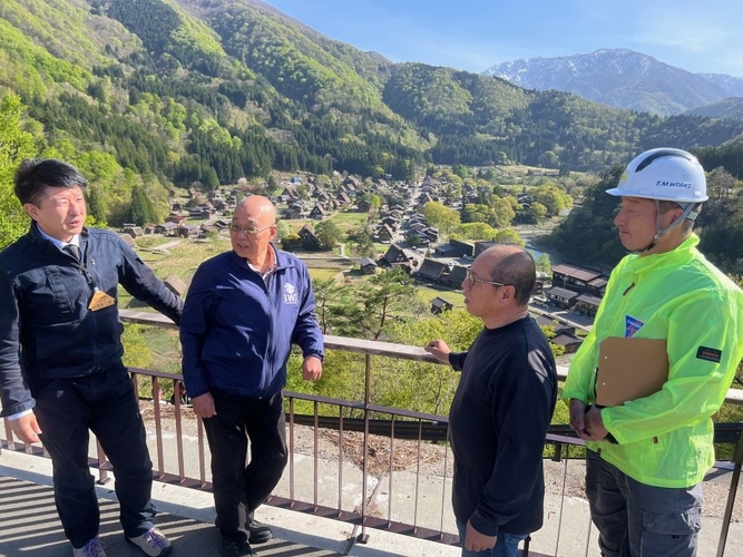 合掌造り集落の展望台で髙島課長（左端）から集落内でのクマの出現状況を聞く（その右から）辻特担教授、轟社長、渡邊さん