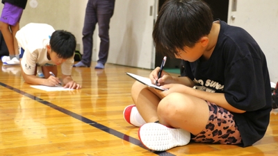 アンケートを書く小学生