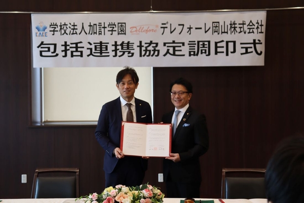 協定書を手にする（左から）加計理事長と尾崎会長