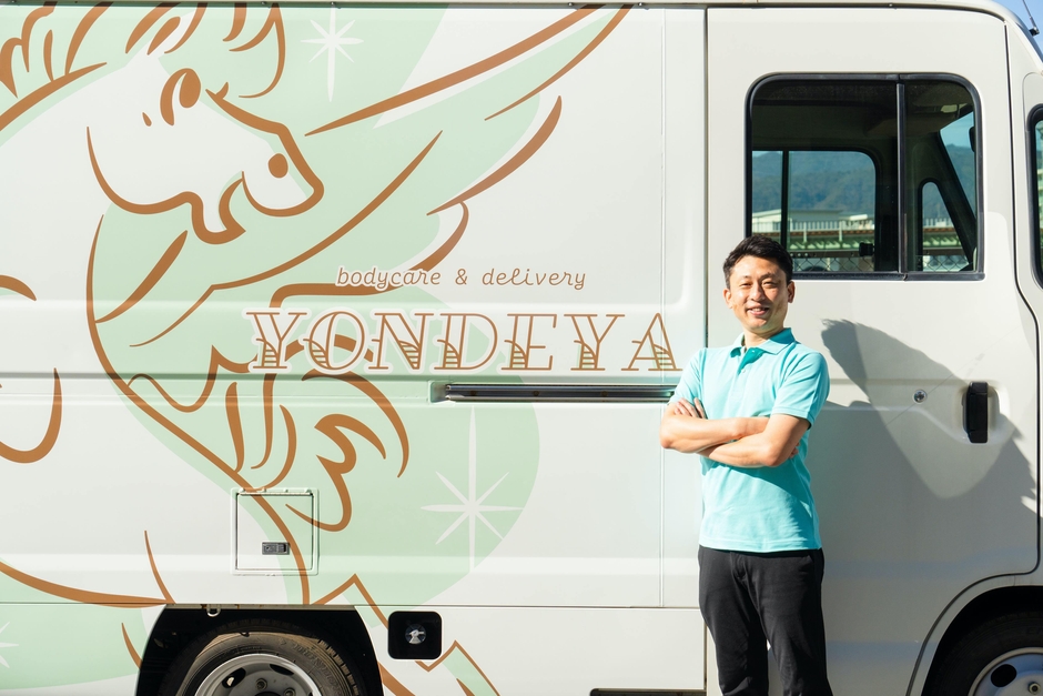 「YONDEYA」の車と代表取締役の大山 恭史