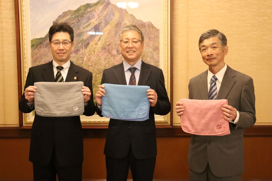 共同開発したペット用タオルを手にする(左から)菅副知事、福岡部長、村田副学部長