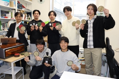 イグサの消臭袋やコースターを手にする（後列左から）指導教員の高橋良平准教授、松田魁斗さん、岡部翔隆さん、上根暖也さん、木村柊斗さん（前列左から）板谷匠晃さん、大西啓太さん