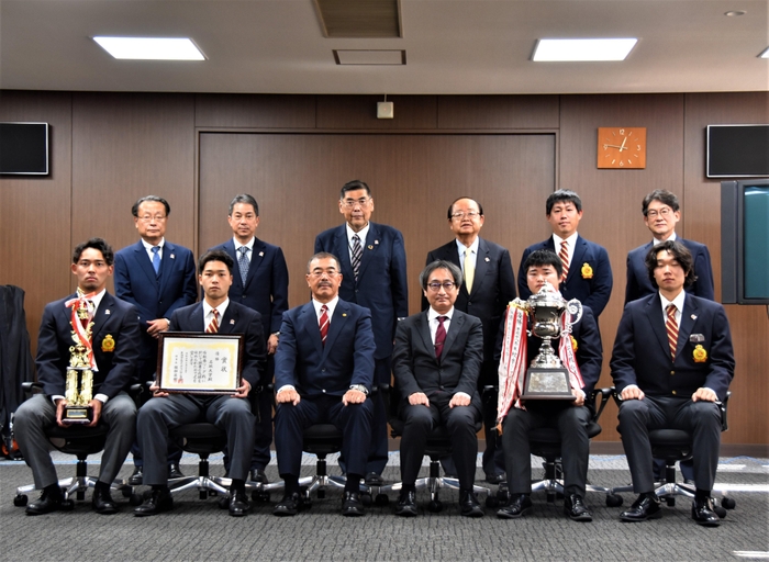 立花理事長(後列右から3人目)と小原学長(同4人目)に優勝報告したアメフト部の皆さん