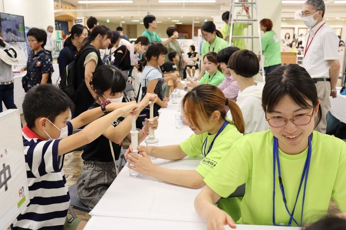 家族連れでにぎわう会場。写真は「空気を使って大実験！」のブース