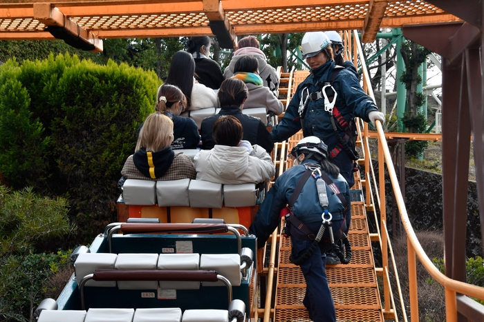 コース途中でアトラクションが緊急停止した想定で、降車の補助および救助を行う様子