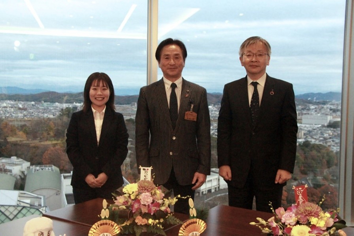 記念写真に納まる（左から）高橋さん、大舌市長、平野学長