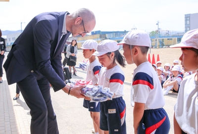 福井 代表:ハンス・ブランケンが児童に傘を贈呈