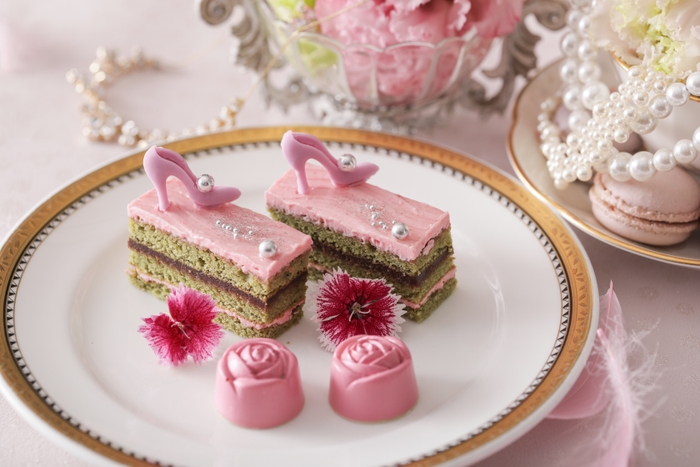 ▲スタンド中段スイーツ ピンクオペラ~チェリーブロッサム~は、生地に桜の葉を使用し、こしあんのガナッシュをサンド、バタークリームには桜の花をパウダーにしたものを使用。洋風の桜餅をイメージ。薔薇のボンボンショコラ~蓬~は、ホワイトガナッシュに国産よもぎを練りこみ春らしい味わいに仕立てた。