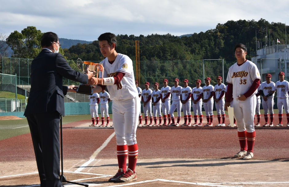 優勝トロフィーを受け取る中村昂央主将(中)と野口泰司選手