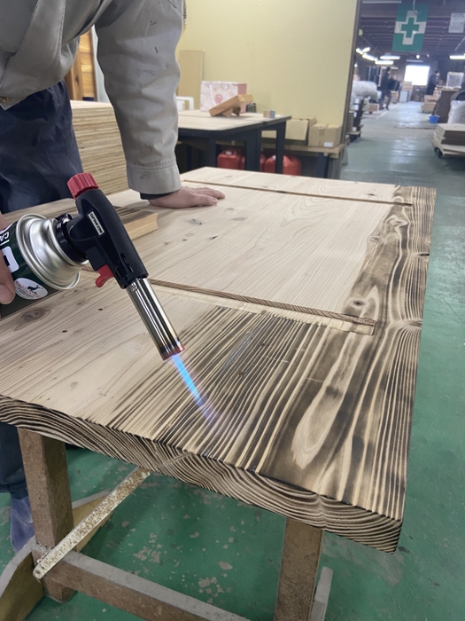 杉材の天板をバーナー加工している様子